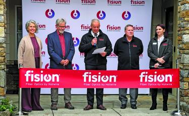 Highlands Chamber of Commerce Executive Director Kaye McHan and Mayor Patrick Taylor joined representatives from Fision by Hotwire for a ribbon cutting ceremony in front of the Highlands office.