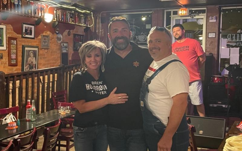 Brent Holbrooks (center) celebrated with family and friends at Rathskeller on Tuesday night as election results showed him the winner in the race for Macon County Sheriff. He is pictured with his sister April Chastain and brother Eric Duvall. Photo by Mia Overton/The Franklin Press